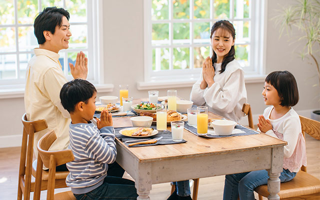 家族4人で食卓を囲んでいる写真